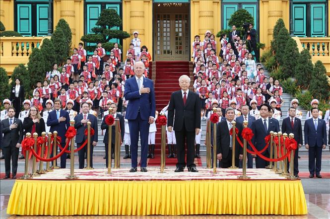 Tổng Bí thư Nguyễn Phú Trọng và Tổng thống Hoa Kỳ Joe Biden trên bục danh dự, thực hiện nghi thức chào cờ.