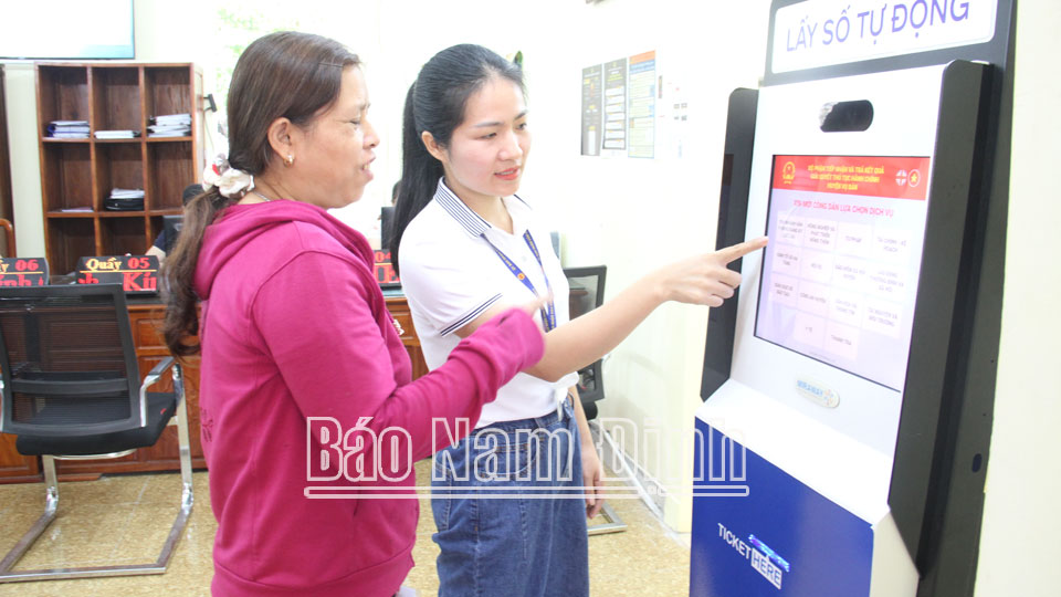 Chuyên viên Văn phòng UBND huyện hướng dẫn người dân sử dụng dịch vụ công trực tuyến.