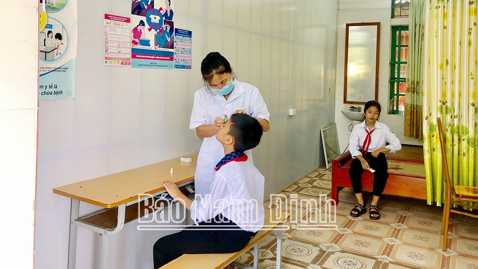 Nhân viên y tế Trường THCS Hải Nam (Hải Hậu) kiểm tra, tư vấn phòng bệnh đau mắt đỏ, tật khúc xạ cho học sinh.
