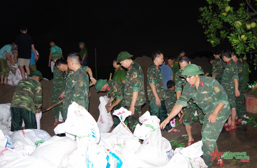 Lực lượng vũ trang cùng người dân hộ đê ứng phó với thiên tại xã Mỹ Tân, phường Lộc Hạ (TP Nam Định). 