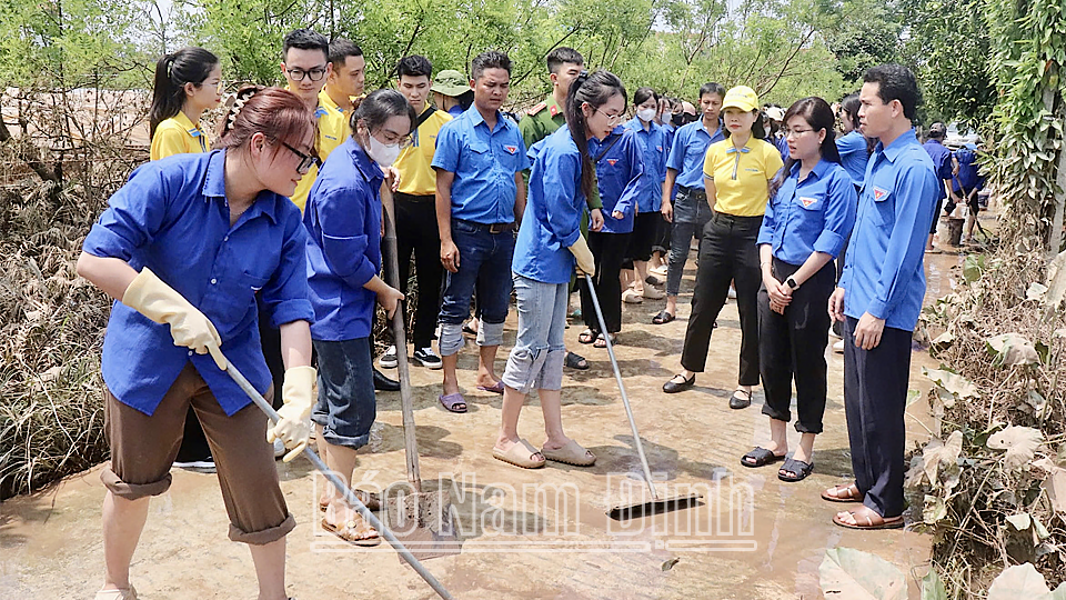 Lực lượng đoàn viên, thanh niên tham gia hỗ trợ người dân Mỹ Tân (thành phố Nam Định) thu gom rác thải, dọn vệ sinh môi trường vùng ngập úng sau cơn bão số 3.
