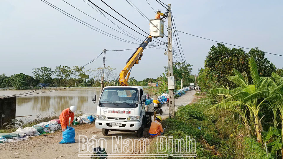 Nhân viên Công ty Điện lực huyện Trực Ninh kiểm tra hệ thống điện đảm bảo an toàn cho người dân thôn Lộ Xuyên, xã Phương Định khi trở về nhà. (ĐT 7)