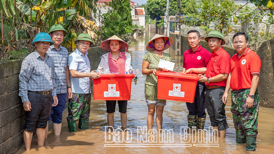 Đồng chí Phó Trưởng ban Thường trực Ban Dân vận Trung ương và lãnh đạo Hội Chữ Thập đỏ Việt Nam tặng quà các hộ dân bị ảnh hưởng bởi bão số 3 tại xã Nghĩa An (Nam Trực). Dt8