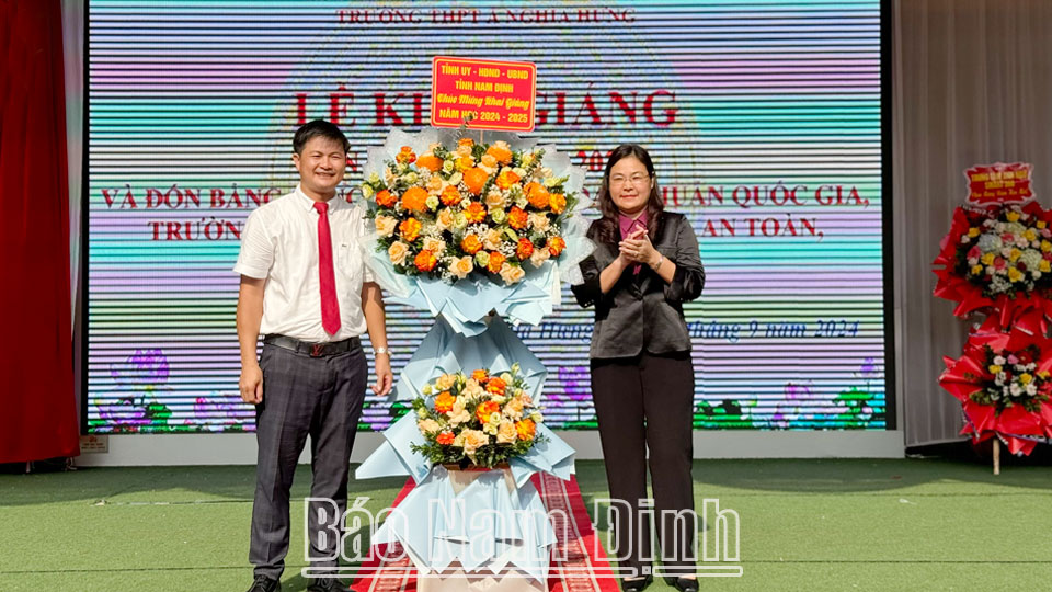 Đồng chí Hà Lan Anh, TUV, Phó Chủ tịch UBND tỉnh tặng hoa chúc mừng thầy và trò Trường THPT A Nghĩa Hưng (Nghĩa Hưng) nhân dịp năm học mới.