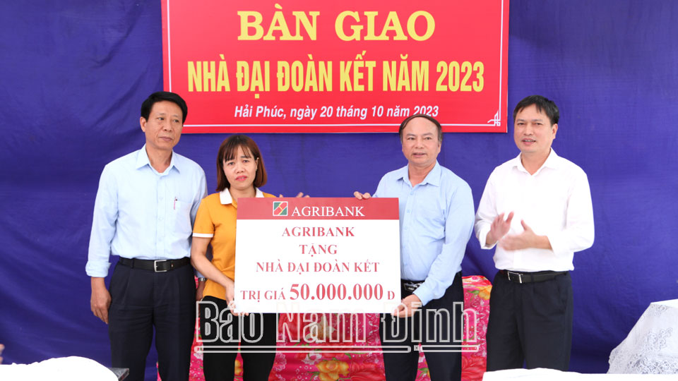 Đại diện Agribank Chi nhánh tỉnh Nam Định trao tặng tiền ủng hộ xây dựng nhà Đại đoàn kết cho chị Trần Thị Nhung ở xóm Thượng Phúc, xã Hải Phúc (Hải Hậu).