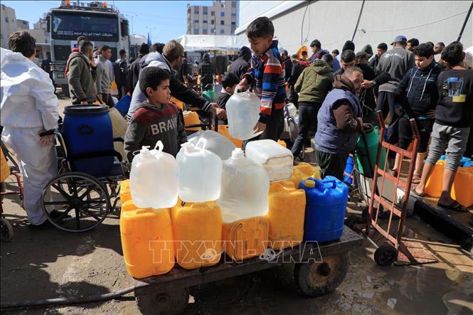 Trẻ em lấy nước tại vòi nước công cộng ở thành phố Rafah, Dải Gaza, ngày 31/1/2024. Ảnh: THX/TTXVN
