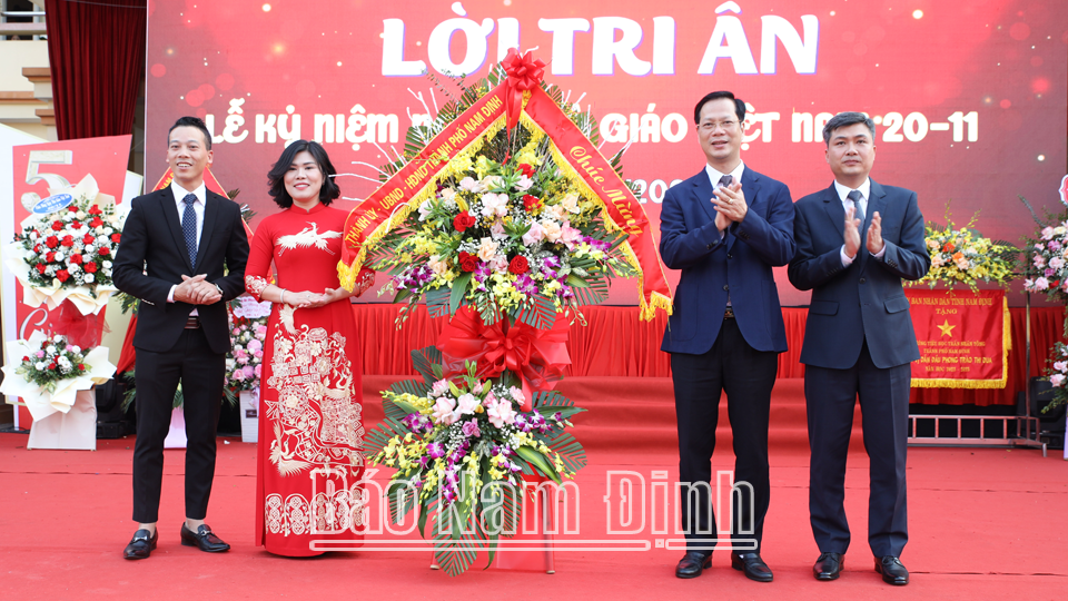 Đồng chí Nguyễn Anh Tuấn, Ủy viên Ban TVTU, Bí thư Thành ủy và đồng chí Chủ tịch UBND Thành phố tặng lẵng hoa tươi thắm chúc mừng cán bộ, giáo viên trường Tiểu học Trần Nhân Tông.