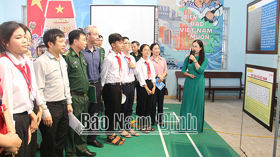 Các đại biểu và học sinh Trường THCS Giao Lạc (Giao Thủy) nghe thuyết minh về chứng tích và pháp lý chủ quyền quần đảo Hoàng Sa, Trường Sa của Việt Nam.ĐT