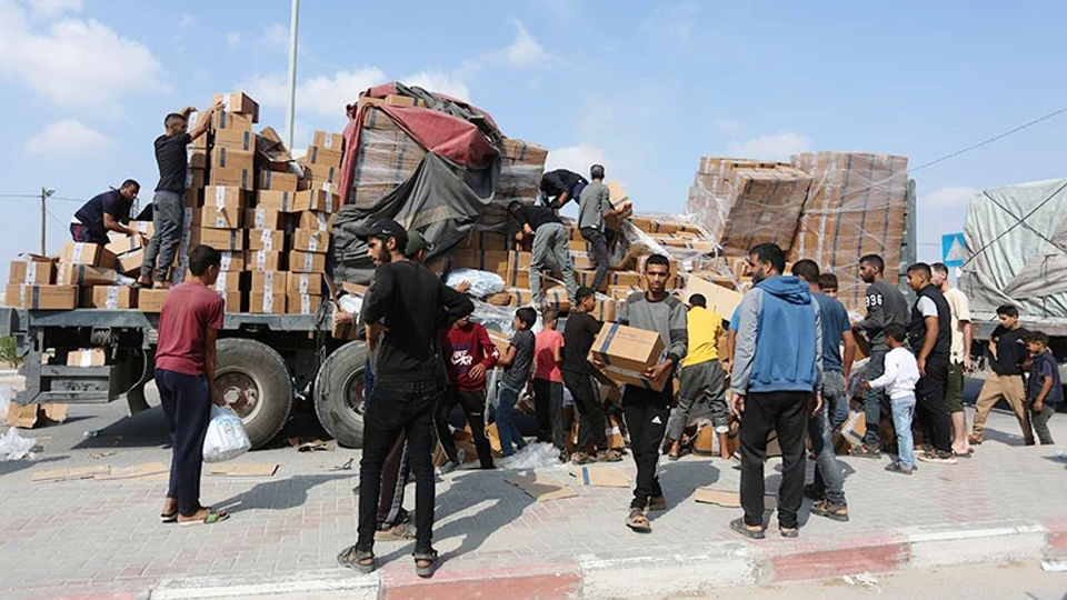 Người dân chuyển hàng cứu trợ nhân đạo tại cửa khẩu Rafah ở Dải Gaza.
