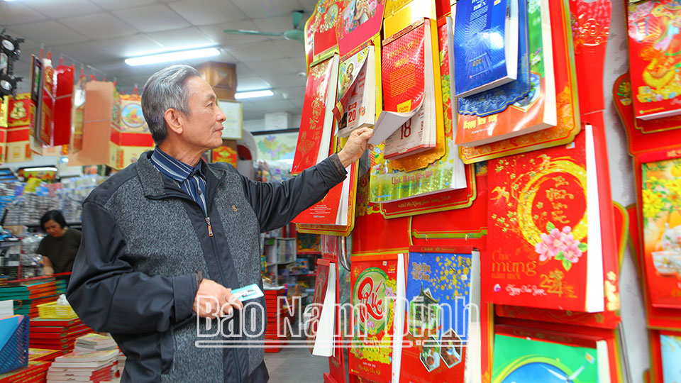 Người dân tìm hiểu và lựa chọn lịch Giáp Thìn 2024 tại Hiệu sách Nhân Dân thành phố Nam Định.