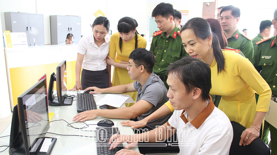 Nhân viên Bưu điện Nam Định hướng dẫn người dân thực hiện nộp hồ sơ thủ tục hành chính trên Cổng dịch vụ công trực tuyến của tỉnh.