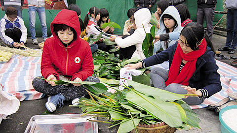 Các TNV CTĐ tham gia gói bánh chưng tặng những người có hoàn cảnh khó khăn. Ảnh: Do Đội TNV CTĐ cung cấp