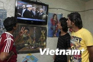 Người dân xem tivi họp báo công bố thành lập liên minh chính trị Shiite. (Nguồn: Vietnamplus)