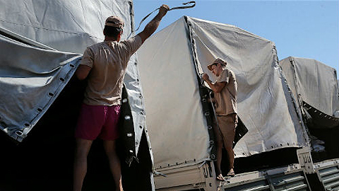 Hàng viện trợ trên xe tải của Nga được bốc dỡ tại Lu-gan-xcơ ngày 22-8. Ảnh: Roi-tơ