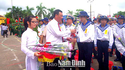 đồng chí Đoàn Hồng Phong, Phó Bí thư Tỉnh ủy, Chủ tịch UBND tỉnh tặng hoa, động viên tân binh huyện Hải Hậu lên đường nhập ngũ.