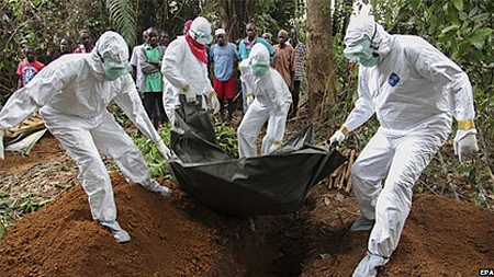 Các nhân viên y tế chôn cất thi thể bệnh nhân Ebola tại Monrovia, Liberia hôm 6-8. (Ảnh: EPA)