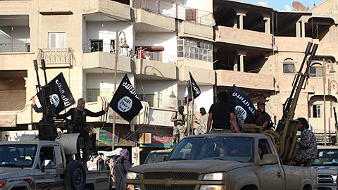 Phiến quân IS tuần hành trên đường phố Xi-ri. Ảnh: Roi-tơ