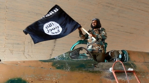 Một chiến binh IS khoe chiến lợi phẩm của mình. Ảnh: AP