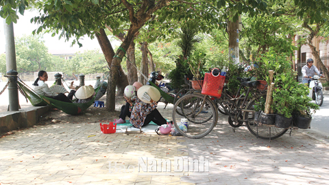 Nhiều người tìm cách tránh nắng dưới bóng râm