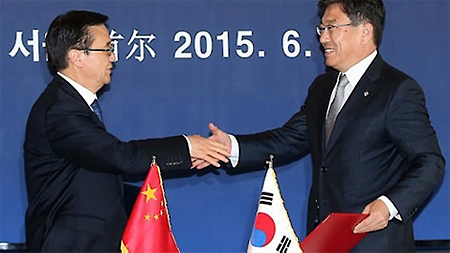 Bộ trưởng Thương mại Hàn Quốc Yoon Sang-jick (bên phải) và người đồng cấp Trung Quốc Gao Hucheng bắt tay sau khi chính thức ký Hiệp định thương mại tự do Trung Quốc-Hàn Quốc, tại một khách sạn ở Thủ đô Seoul, Hàn Quốc, ngày 1-6-2015. (Ảnh: Yonhap)