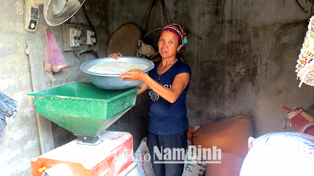 Bà Lương Thị Mai, đội 9, Thị trấn Cổ Lễ (Trực Ninh) đang xay xát thóc chuẩn bị cho buổi chợ mới.