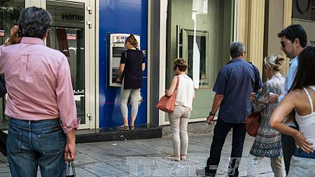 Người dân Hy Lạp xếp hàng đợi rút tiền từ ATM ở thủ đô Athens. Ảnh: AFP/TTXVN