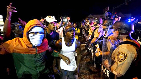 Những người biểu tình la hét trước hàng rào cảnh sát tại Ferguson, bang Missouri, Mỹ, đêm ngày 9-8-2015. (Ảnh: Reuters)