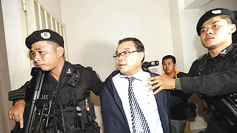 Cảnh sát Căm-pu-chia áp giải nghị sĩ đảng đối lập Hông Sốc Hua đến tòa án Phnôm-pênh. Ảnh: Roi-tơ