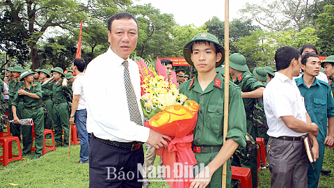 Đồng chí Đoàn Hồng Phong, Phó Bí thư Tỉnh ủy, Chủ tịch UBND tỉnh, tặng hoa, động viên tân binh Thành phố Nam Định trước khi lên đường nhập ngũ.