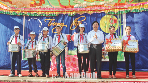 Đồng chí Đoàn Hồng Phong, Bí thư Tỉnh ủy, Chủ tịch UBND tỉnh tặng quà cho các cháu thiếu nhi tại Trại thu xã Nam Phong, Thành phố Nam Định (ảnh bên trái); Đồng chí Trần Văn Chung, Phó Bí thư Tỉnh uỷ, Chủ tịch HĐND tỉnh tặng quà các cháu thiếu nhi tại Trại thu xã Trực Thanh, huyện Trực Ninh (ảnh bên phải). Ảnh: Việt Thắng và Đức Thiện