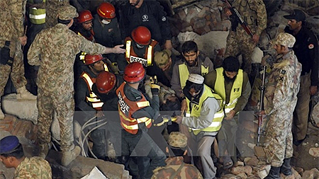 Lực lượng cứu hộ tìm kiếm các nạn nhân trong vụ sập nhà máy. Ảnh: TTXVN