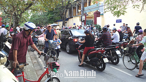 Phụ huynh đứng đón con dưới lòng đường trước cổng Trường Tiểu học Trần Quốc Toản, đường Phạm Hồng Thái (TP Nam Định).