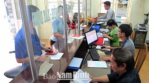 Cán bộ phường Nguyễn Du (TP Nam Định) giải quyết thủ tục hành chính phục vụ nhân dân tại bộ phận “một cửa”.