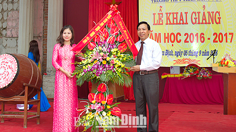 Đồng chí Trần Văn Chung, Phó Bí thư Thường trực Tỉnh ủy, Chủ tịch HĐND tỉnh tặng thầy và trò Trường THPT Trần Hưng Đạo lẵng hoa tươi thắm