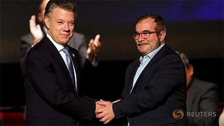 Tổng thống Colombia Juan Manuel Santos (bên trái) và thủ lĩnh lực lượng vũ trang cách mạng Colombia (FARC) Rodrigo Londono bắt tay sau khi ký hiệp định hòa bình sửa đổi tại Bogota, Colombia, ngày 24-11-2016. (Ảnh: Reuters)