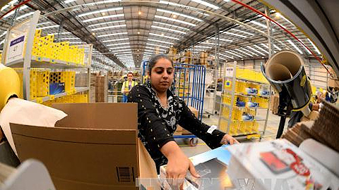 Công nhân làm việc tại một trung tâm của tập đoàn Amazon ở Peterborough, Anh. Ảnh: AFP/TTXVN