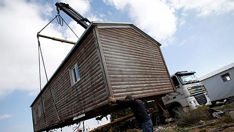 Một người đàn ông hỗ trợ di dời một ngôi nhà dựng sẵn khỏi khu định cư bất hợp pháp Amona, tại khu vực chiếm đóng ở Bờ Tây, ngày 6-2-2017. (Ảnh: Reuters)