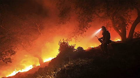 Một lính cứu hỏa giám sát một đám cháy tại hạt Sonoma, bang California, Mỹ, ngày 11-10. (Ảnh: AP)