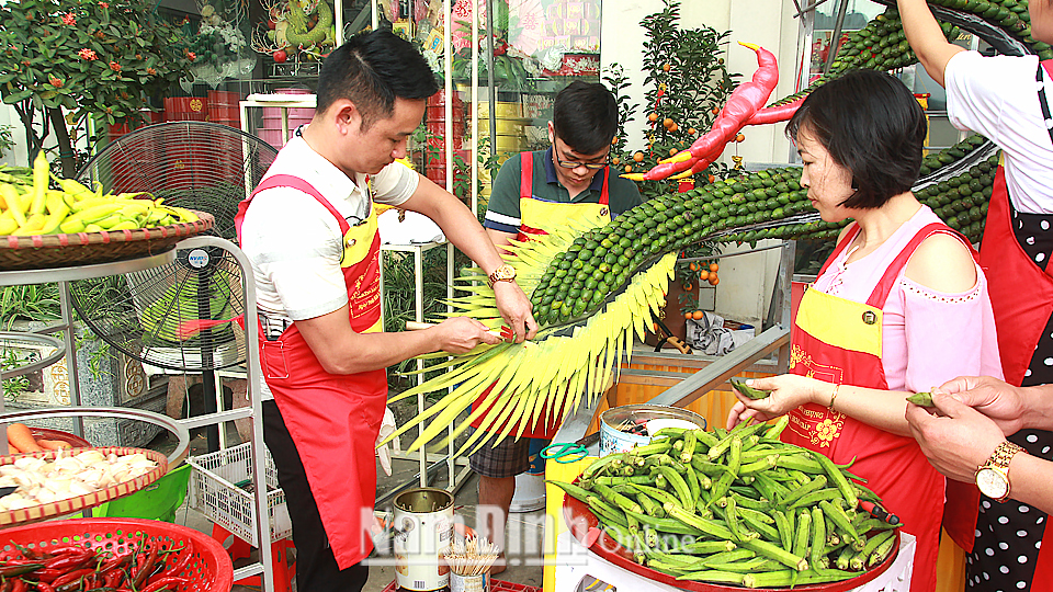 Anh Lê Quang Tú (bên trái) và các học viên đang tạo hình nghệ thuật bằng các loại hoa quả.