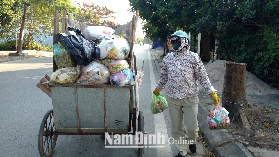 Thu gom rác thải trên tuyến đường Vũ Hữu Lợi, tại xã Nam Vân (thành phố Nam Định).