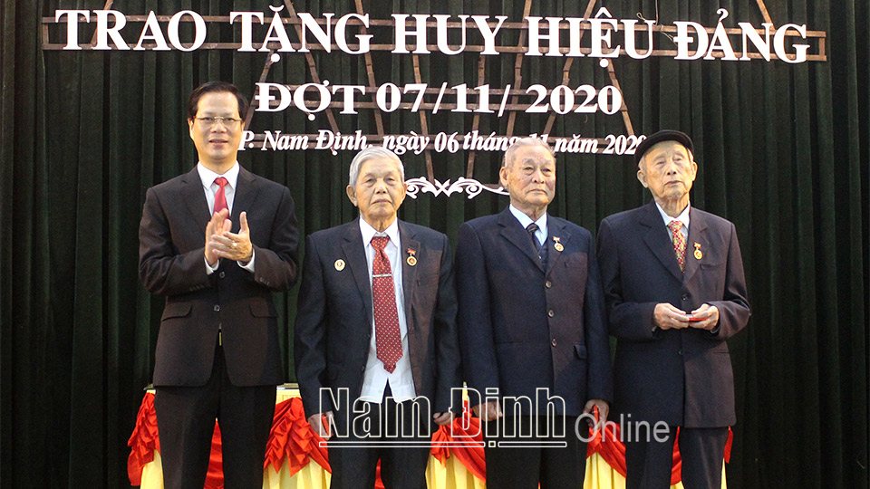 Đồng chí Nguyễn Anh Tuấn, Ủy viên Ban TVTU, Bí thư Thành ủy Nam Định trao tặng Huy hiệu Đảng cho các đảng viên 65 năm tuổi Đảng. Ảnh: Lam Hồng