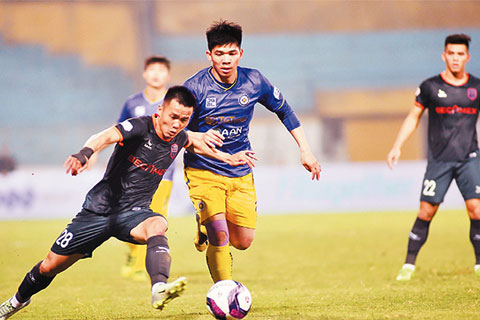 Pha tranh bóng giữa cầu thủ đội Hà Nội FC (áo tím) và cầu thủ đội Becamex Bình Dương. Ảnh: ĐỨC ANH