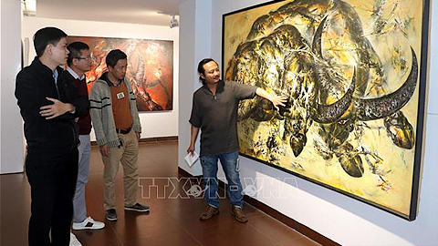 Họa sĩ Ngô Thanh Hùng giới thiệu về nét đẹp của con trâu trong văn hóa Việt qua tranh vẽ được trưng bày tại triển lãm.