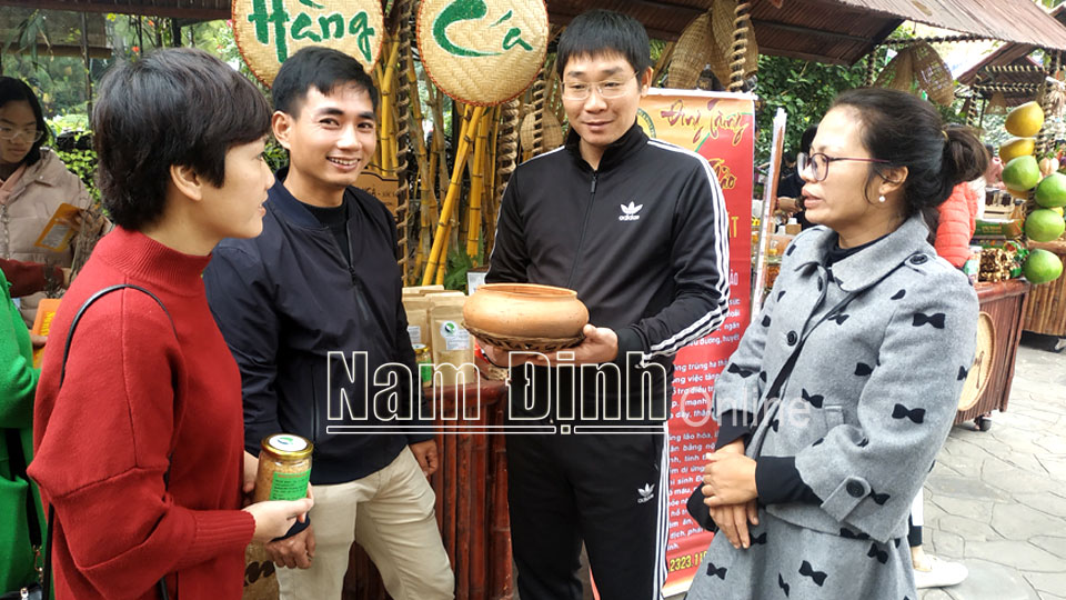 Anh Trần Văn Khoa (thứ 3 từ phải sang) chủ trang trại An Nhiên, xã Mỹ Hà (Mỹ Lộc) trao đổi với khách hàng về sản phẩm của trang trại.