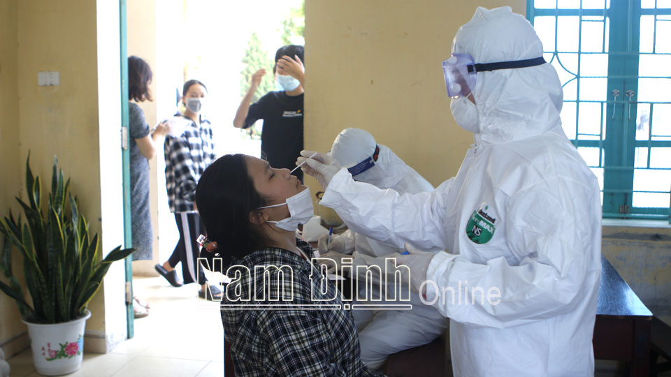 Cán bộ, nhân viên Trung tâm Kiểm soát bệnh tật tỉnh Nam Định tiến hành lấy mẫu xét nghiệm cho 64 cán bộ, giáo viên, nhân viên và 938 học sinh Trường THPT Lê Quý Đôn (Trực Ninh).