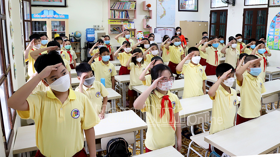 Các em học sinh lớp 4A3, Trường Tiểu học Phạm Hồng Thái (TP Nam Định) thực hiện nghi thức chào cờ đầu năm học tại lớp học.