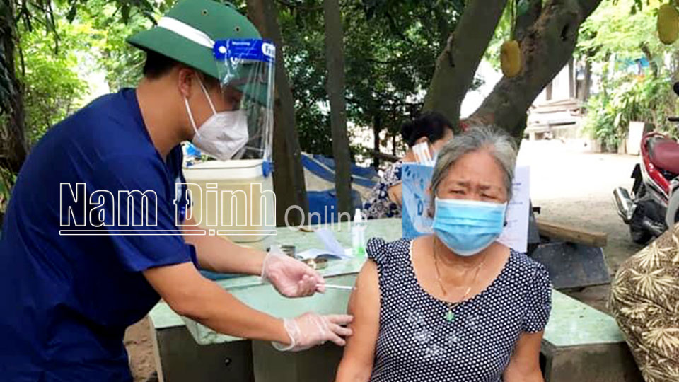 Thầy giáo Đinh Công Trứ, trưởng nhóm 9, Trường Đại học Điều dưỡng Nam Định tiêm vắc-xin phòng COVID-19 cho người dân ở Đồng Nai.