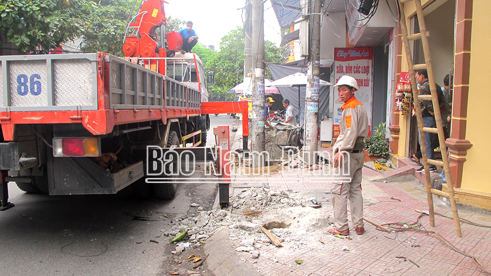 Điện lực Nam Định phối hợp với các doanh nghiệp viễn thông chỉnh trang hệ thống dây cáp trên đường Trần Huy Liệu (thành phố Nam Định).