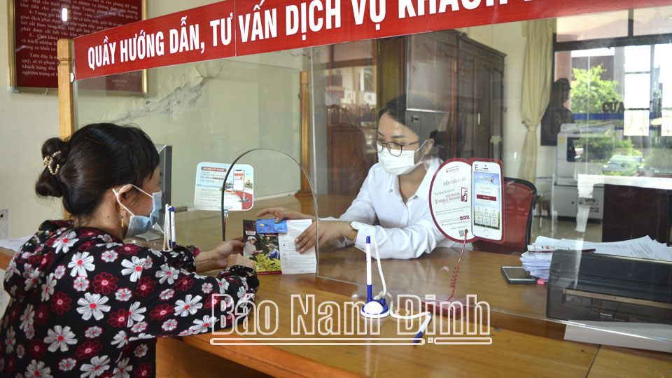 Cán bộ tín dụng dịch vụ Ngân hàng Nông nghiệp và Phát triển nông thôn Việt Nam Chi nhánh Vụ Bản hướng dẫn khách hàng sử dụng tiện ích trên thẻ điện tử.