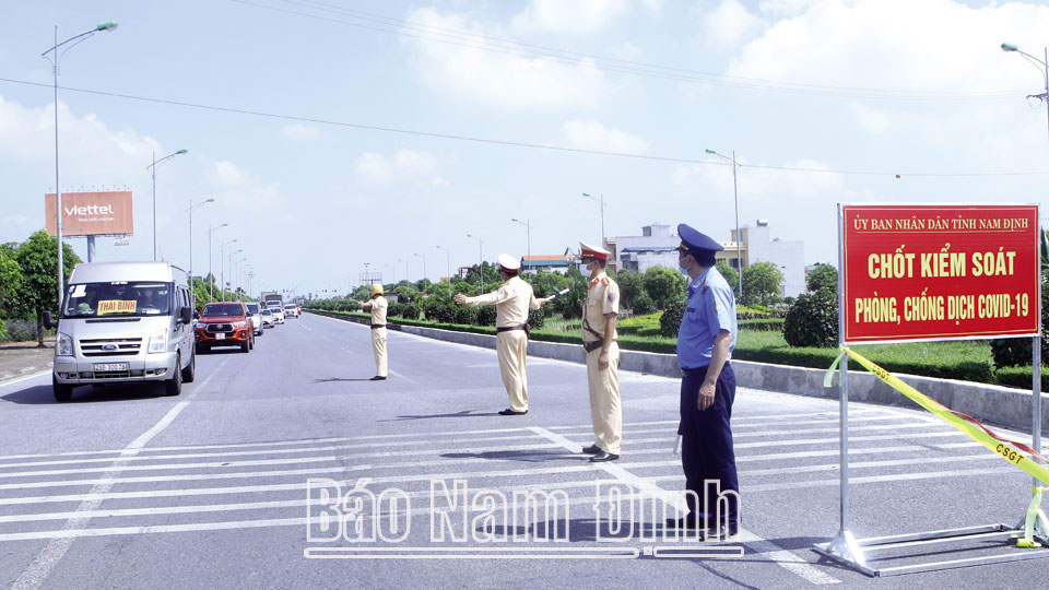 Lực lượng Cảnh sát Cơ động trong diễn tập khu vực phòng thủ tỉnh (ảnh trên); Lực lượng cảnh sát giao thông tham gia kiểm soát người và phương tiện ra vào tỉnh tại chốt kiểm dịch Mỹ Lộc (ảnh dưới). Ảnh: Xuân Thu và Việt Thắng